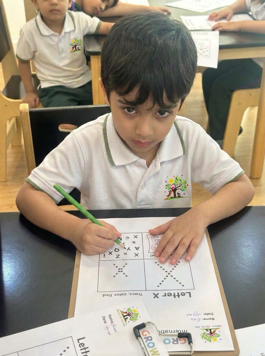 A child tracing and colouring the letter X